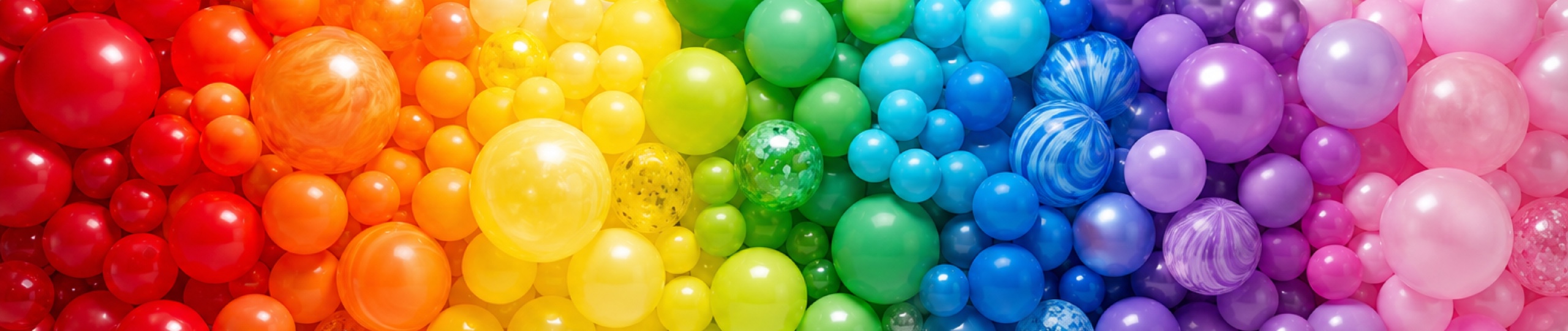 Wall of balloons arranged as a rainbow color spectrum